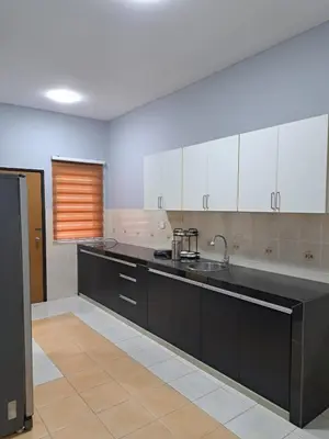 a large kitchen with black counters and white cabinets at Double-story House in Kuala Lumpur in Ampang