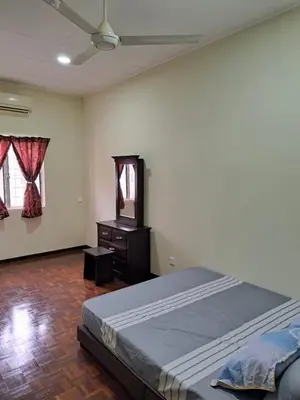 a bedroom with a bed and a dresser and a television at Double-story House in Kuala Lumpur in Ampang
