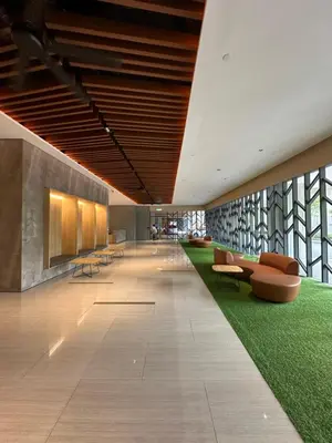 a lobby with chairs and a green carpet at Sunway Velocity Two Deluxe in Kuala Lumpur