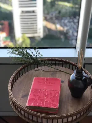 a table with a vase and a book on it at Sky Suites KLCC by Psalm Space exclusively for female travellers in Kuala Lumpur