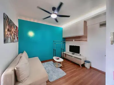 a living room with a couch and a blue wall at Comfy Studio Casa Mutiara, Near LRT Hang Tuah & Lalaport in Kuala Lumpur