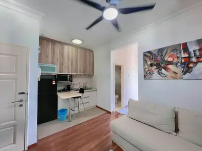 a living room with a couch and a kitchen at Comfy Studio Casa Mutiara, Near LRT Hang Tuah & Lalaport in Kuala Lumpur