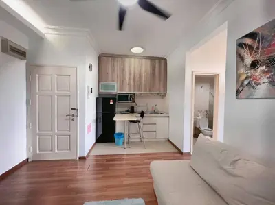 a living room with a couch and a kitchen at Comfy Studio Casa Mutiara, Near LRT Hang Tuah & Lalaport in Kuala Lumpur