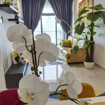 a vase with white flowers in a living room at Badang Homestay KLCC in Kuala Lumpur