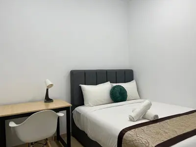 a bedroom with a bed and a desk and a chair at Eaton Residence Suites KLCC in Kuala Lumpur