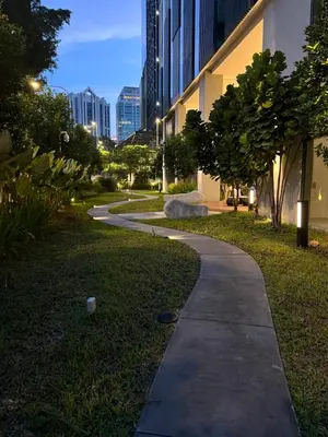 a sidewalk in a park with a building at Eaton Residence Suites KLCC in Kuala Lumpur
