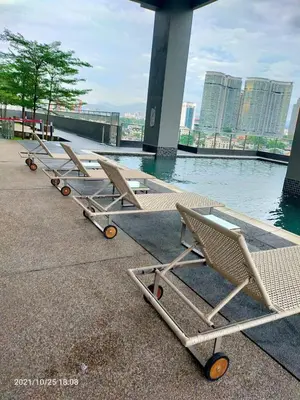 a row of lounge chairs sitting next to a body of water at Sophia Homestay KLCC in Kuala Lumpur