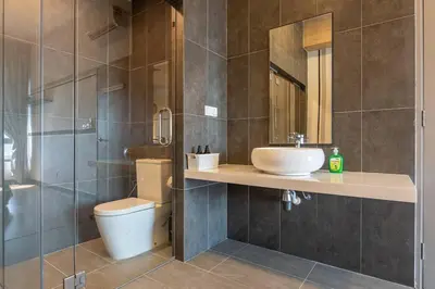 a bathroom with a sink and a toilet and a mirror at Modern Design 2BR Astoria in Kuala Lumpur