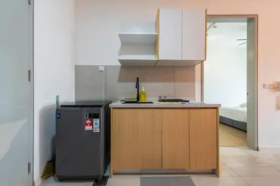 a small kitchen with a refrigerator next to a counter at The Pano by Minsu in Kuala Lumpur