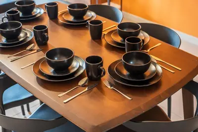 a wooden table with black cups and saucers on it at The Pano by Minsu in Kuala Lumpur