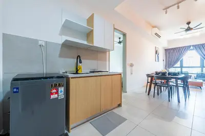 a kitchen with a refrigerator and a table with chairs at The Pano by Minsu in Kuala Lumpur