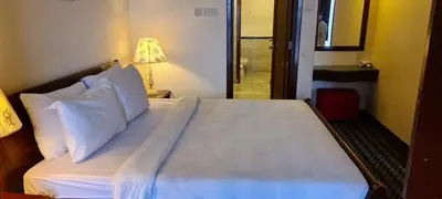a bed with white sheets and pillows in a room at Soho Service Suite at Times Square KL in Kuala Lumpur