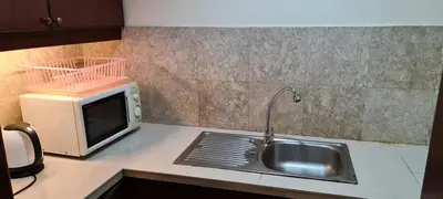 a kitchen counter with a sink and a microwave at Soho Service Suite at Times Square KL in Kuala Lumpur
