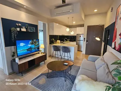 a living room with a couch and a tv and a kitchen at Star Residence T1, 2br Unit Floor 36 in Kuala Lumpur
