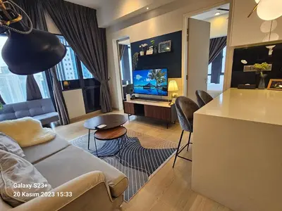 a living room with a couch and a kitchen with a tv at Star Residence T1, 2br Unit Floor 36 in Kuala Lumpur