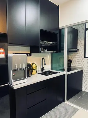 a kitchen with black cabinets and a white counter top at Ayazuki Sky Suite KLCC View 2BR Free Parking Netflix Swimming Pool in Kuala Lumpur