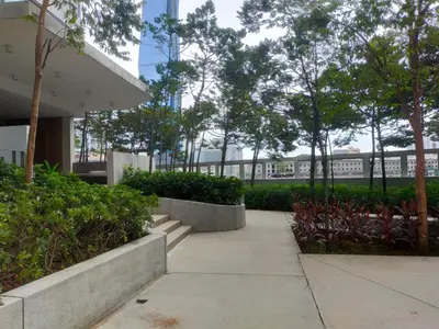 a sidewalk in front of a building with trees and bushes at Mid Night Realm Kuala Lumpur in Kuala Lumpur