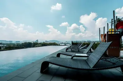 a row of chairs sitting on the edge of a pool at Expressionz KLCC By Sky Homez in Kuala Lumpur