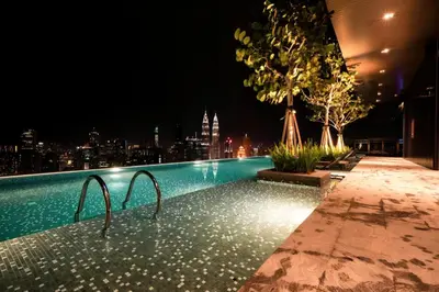 a swimming pool with a view of a city at night at Expressionz KLCC By Sky Homez in Kuala Lumpur