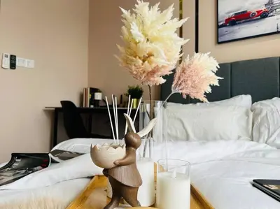 a table with a vase of flowers on a bed at MVA17#Family Suite 8pax 3 Rooms M Vertica Velocity Mall Cheras IKEA Mytown Short Walk to MRT & LRT Maluri in Kuala Lumpur