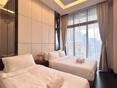 two beds in a hotel room with a window at Dorsett Residence Kuala Lumpur 8 pax in Kuala Lumpur