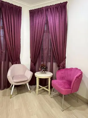 two chairs and a table in a room with purple curtains at Titiwangsa Premium Villa KL by uBook in Kuala Lumpur
