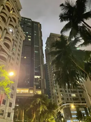 a city street with tall buildings and palm trees at Binjai 8 Soho Premium Near KLCC & LRT KLCC in Kuala Lumpur