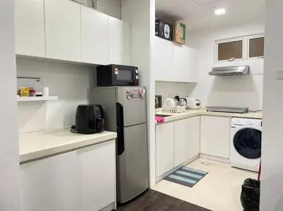 a small kitchen with white cabinets and a refrigerator at Binjai 8 Soho Premium Near KLCC & LRT KLCC in Kuala Lumpur