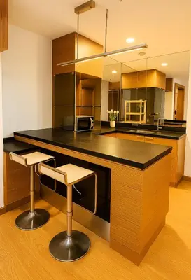 a kitchen with a black counter and two bar stools at KL Sentral Dua Sentral Cozy Homestay Apartments by Hollywood Homes #FreeCarPark in Kuala Lumpur