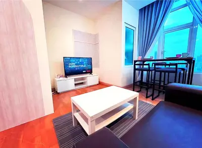 a living room with a television and a table in it at KL Sentral Dua Sentral Cozy Homestay Apartments by Hollywood Homes #FreeCarPark in Kuala Lumpur