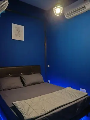 a blue bedroom with a bed with a blue wall at Monkey Mansion Signature in Kuala Lumpur