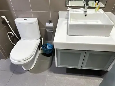 a bathroom with a white sink and a toilet at Summer Suites KLCC By CityHomes in Kuala Lumpur
