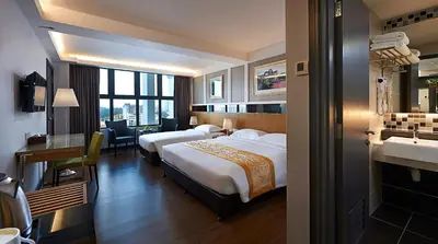 a hotel room with two beds and a desk at Hotel Transit Kuala Lumpur in Kuala Lumpur