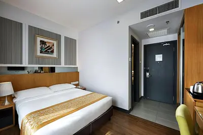 a hotel room with a large bed and a door at Hotel Transit Kuala Lumpur in Kuala Lumpur