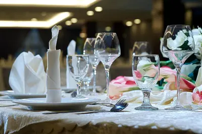 a table with wine glasses and plates on it at Hotel Transit Kuala Lumpur in Kuala Lumpur
