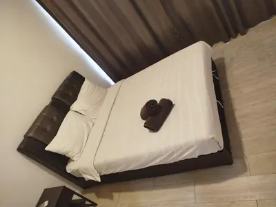a white bed with a chocolate item on it at M City Ampang By Klcc View in Kuala Lumpur