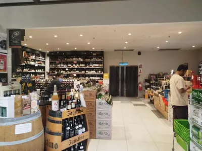 a wine store with two people standing in the aisle at M City Ampang By Klcc View in Kuala Lumpur