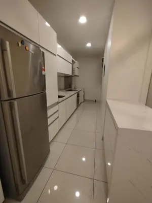 a kitchen with a stainless steel refrigerator and white cabinets at M City Ampang By Klcc View in Kuala Lumpur