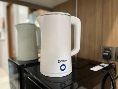 a white electric kettle sitting on top of a stove at Soho Suites KLCC by DeUrban in Kuala Lumpur