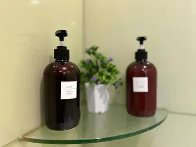 two bottles of soap sitting on a glass shelf at Soho Suites KLCC by DeUrban in Kuala Lumpur