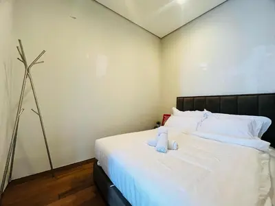 a bedroom with a bed with a teddy bear on it at Soho Suites KLCC by DeUrban in Kuala Lumpur