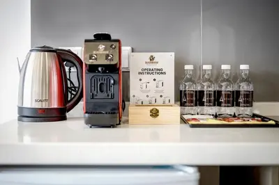 a counter with a coffee maker and bottles of alcohol at Ayatt Bukit Bintang in Kuala Lumpur