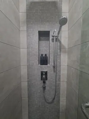 a shower in a bathroom with a tile wall at Muji Themed Apartment by Zen Sojourn - Opposite KL SENTRAL in Kuala Lumpur