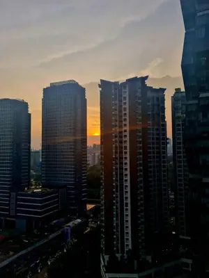 a group of tall buildings in a city at sunset at Muji Themed Apartment by Zen Sojourn - Opposite KL SENTRAL in Kuala Lumpur