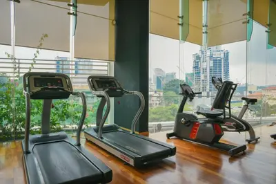 a gym with three cardio machines in front of a window at Couple Suite at Casa Residency 5 mins walk to LRT, Jalan Alor & Bukit Bintang in Kuala Lumpur