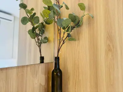 a bottle of wine with a plant on a wall at Quill Residence KL by DeUrban in Kuala Lumpur