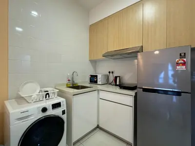 a small kitchen with a dishwasher and a refrigerator at Arte mont kiara by Sweet home in Kuala Lumpur