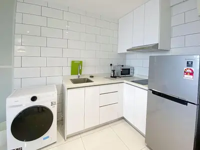 a white kitchen with a sink and a dishwasher at Arte mont kiara by Sweet home in Kuala Lumpur