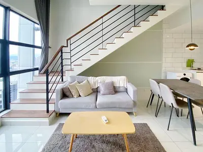 a living room with a couch and a staircase at Arte mont kiara by Sweet home in Kuala Lumpur