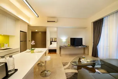 a kitchen and living room with a couch and a table at The Signature Hotel & Serviced Suites Hartamas Kuala Lumpur in Kuala Lumpur